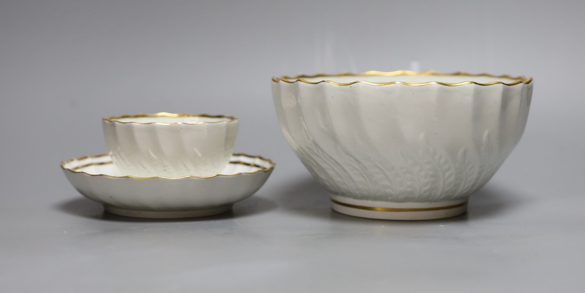 A Neale and Co rare teabowl and saucer and a matching bowl, each piece with acanthus leaf and spirally shanked moulding, the interiors with a gilt floret design, within gilt line borders, for a similar teabowl see Michae